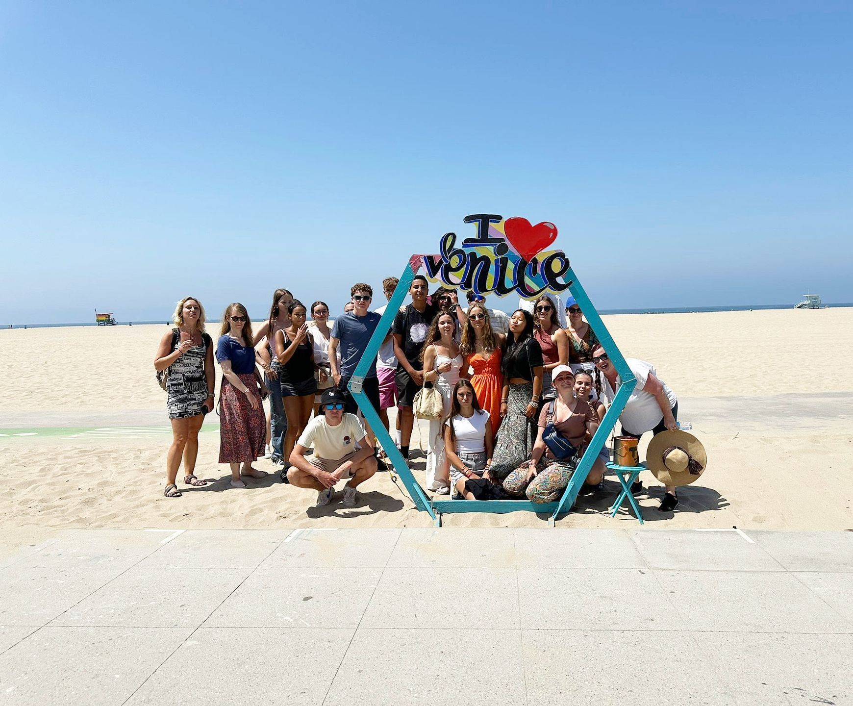 A group of people are posing for a picture in front of a sign that says `` i love venice ''.
