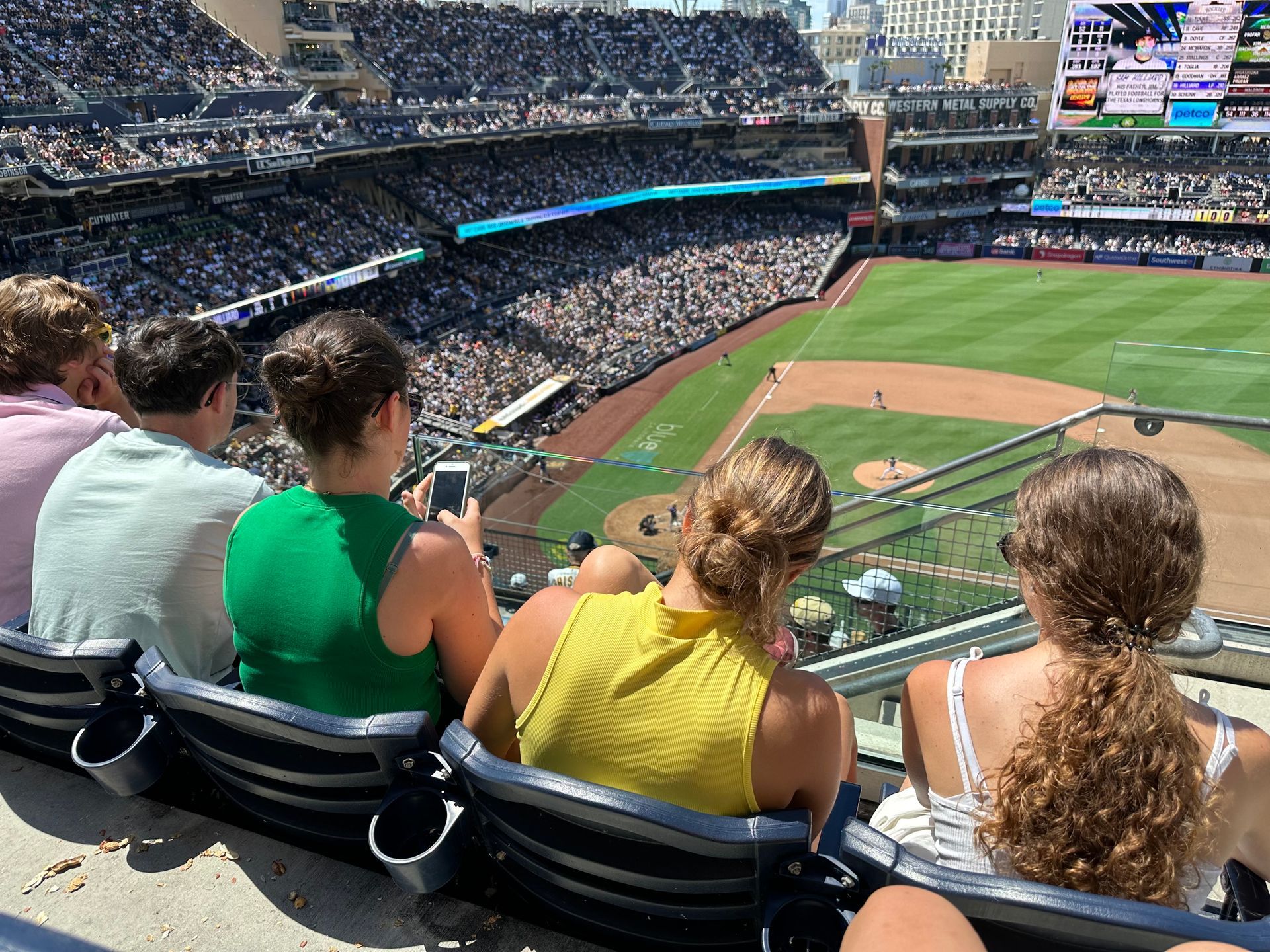 A group of people are sitting in a stadium watching a baseball game.