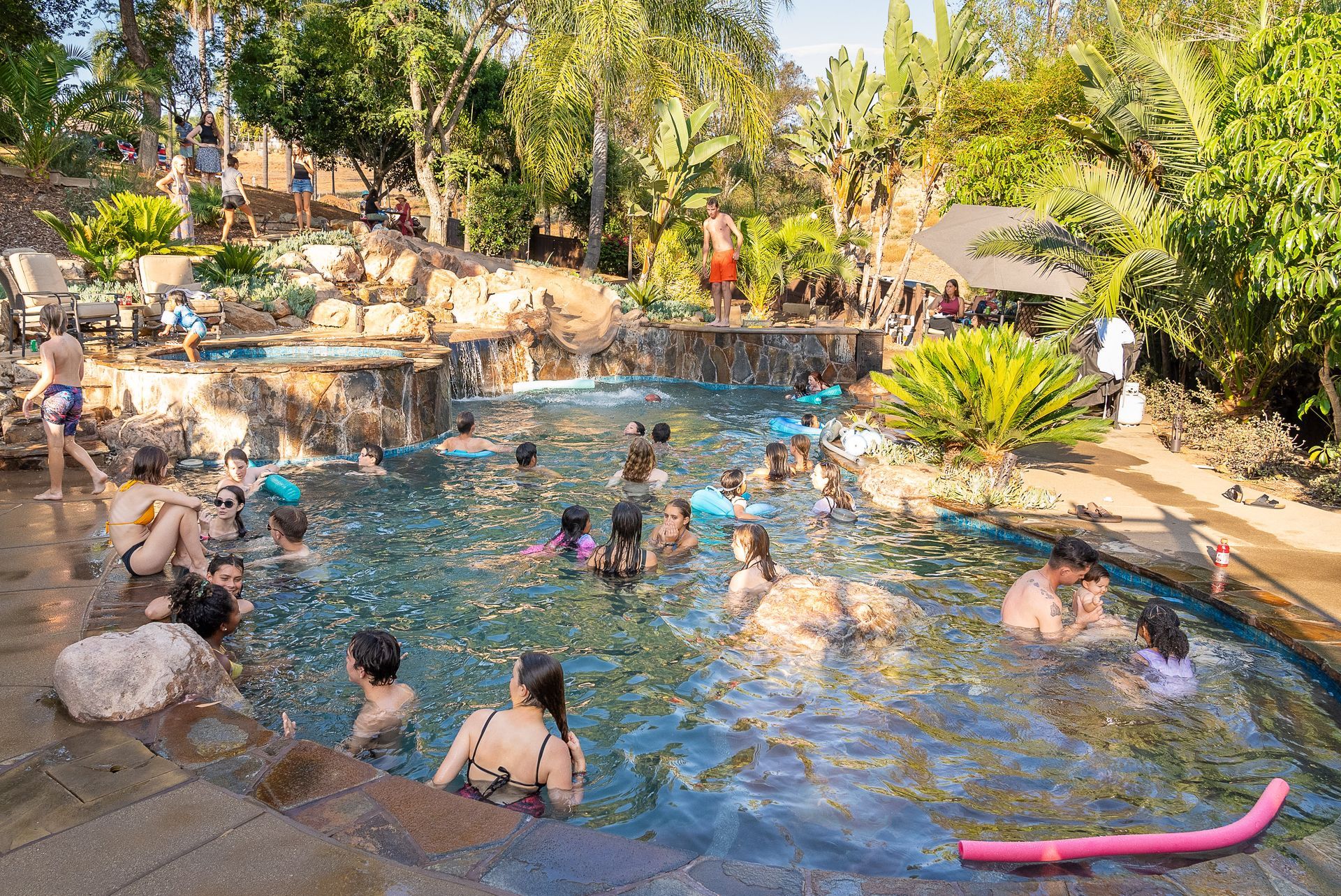A group of people are swimming in a large swimming pool.