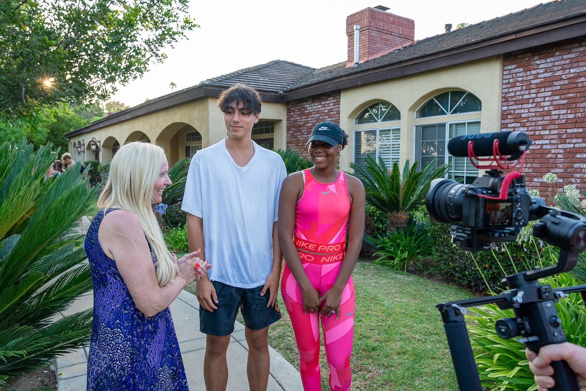 A woman is talking to a man and a woman in front of a camera.