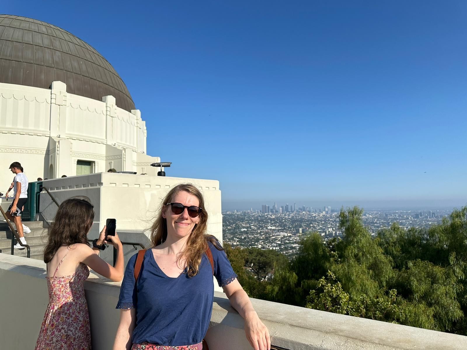 A woman and a girl are standing in front of a dome.