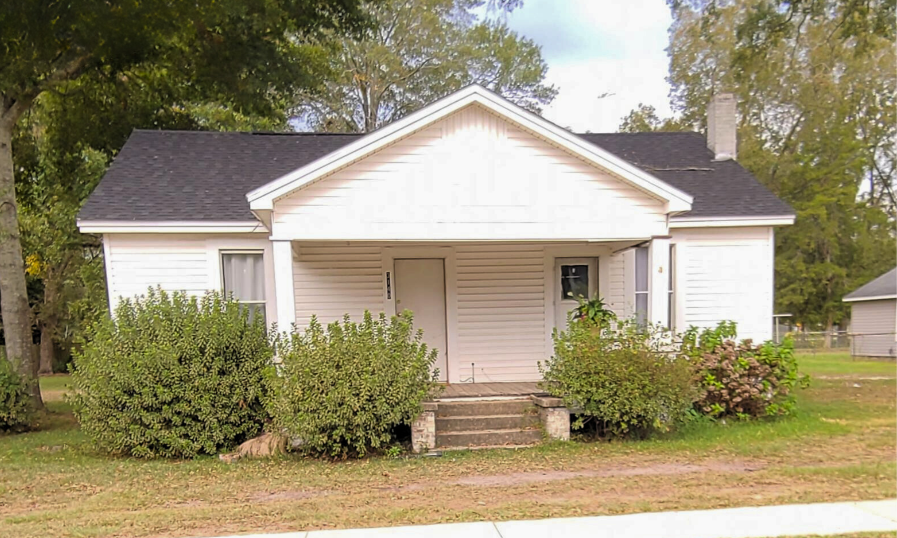 A small white house with a black roof