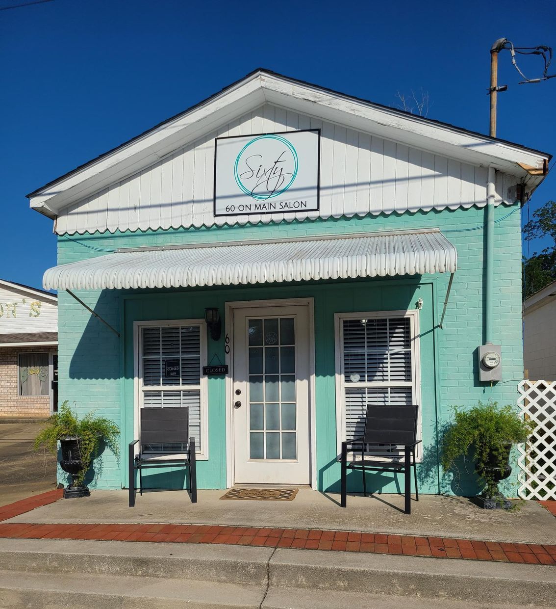 A small green building with a white awning over the door