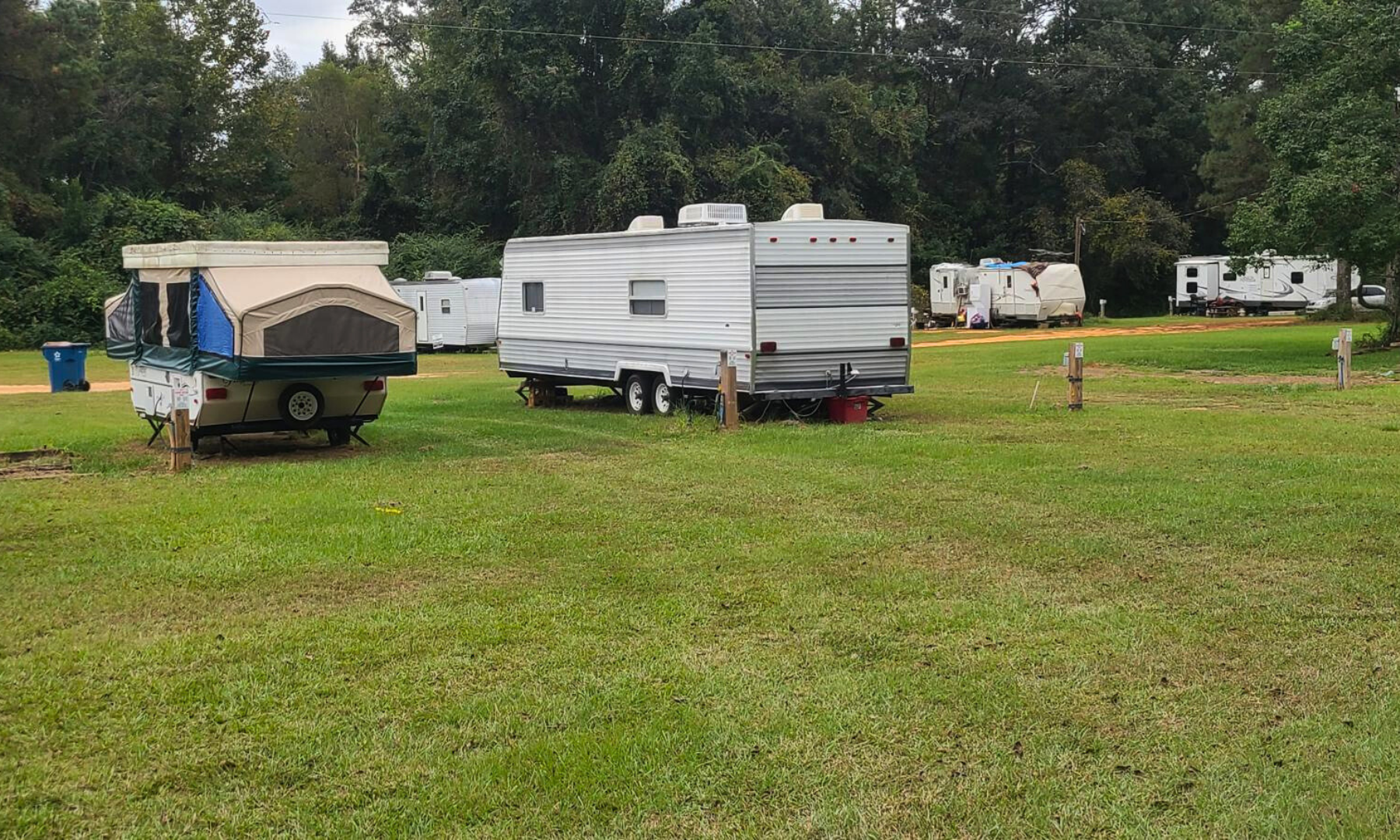 A group of rvs are parked in a grassy field.