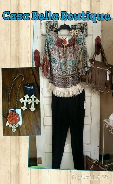 Boho patterned blouse and black pants displayed with necklace and earrings in boutique setting
