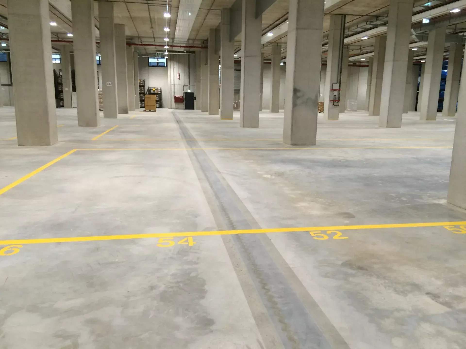 Empty concrete parking garage with yellow lane markings and support columns