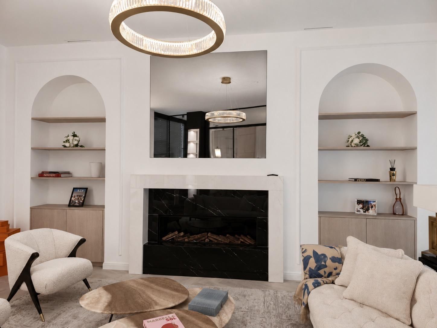 Un salon avec une chaise blanche, une armoire en bois et un cadre photo sur le mur.