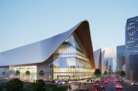 Modern glass-and-steel civic building with a sweeping curved roof at dusk, city traffic in front