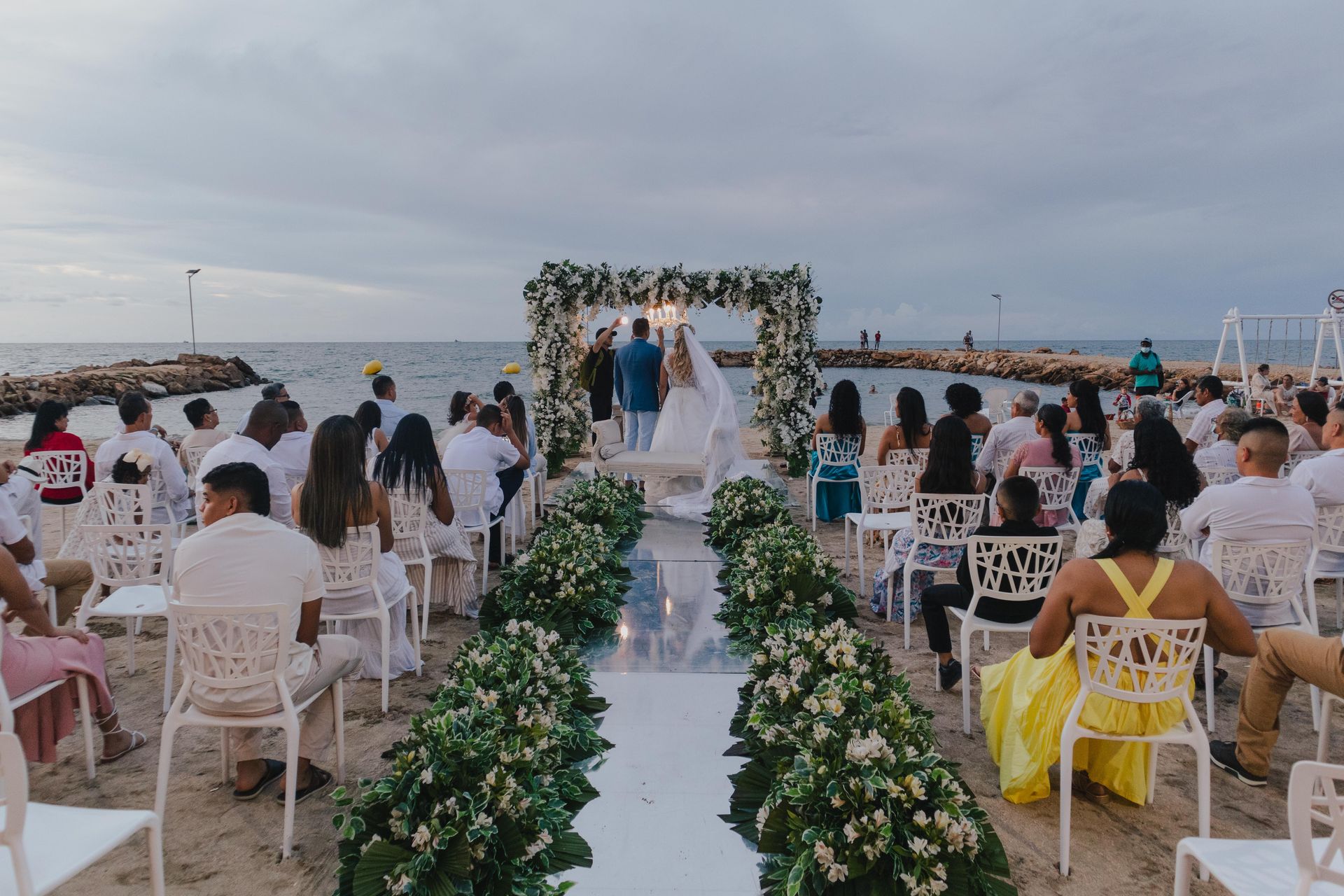 Montaje con flores, incitados sentados, ceremonia para bodas en la playa en el Hotel Poblado