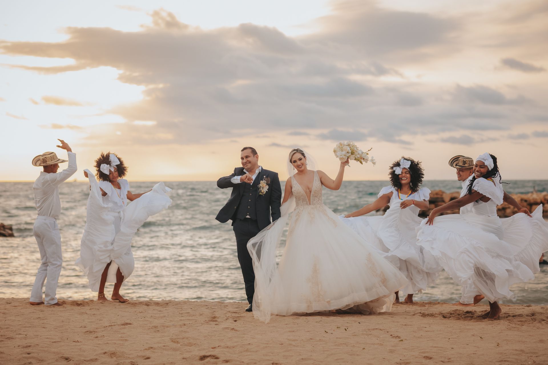 Beachfront wedding couple celebrating at Hotel Poblado Coveñas with guests dressed in white