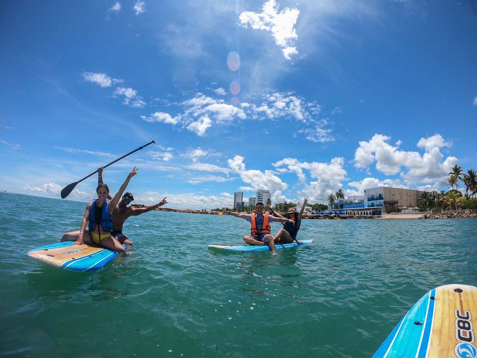 Guests paddle boarding on the sea, one of the activities to do in Coveñas during their stay at Hotel Poblado Coveñas