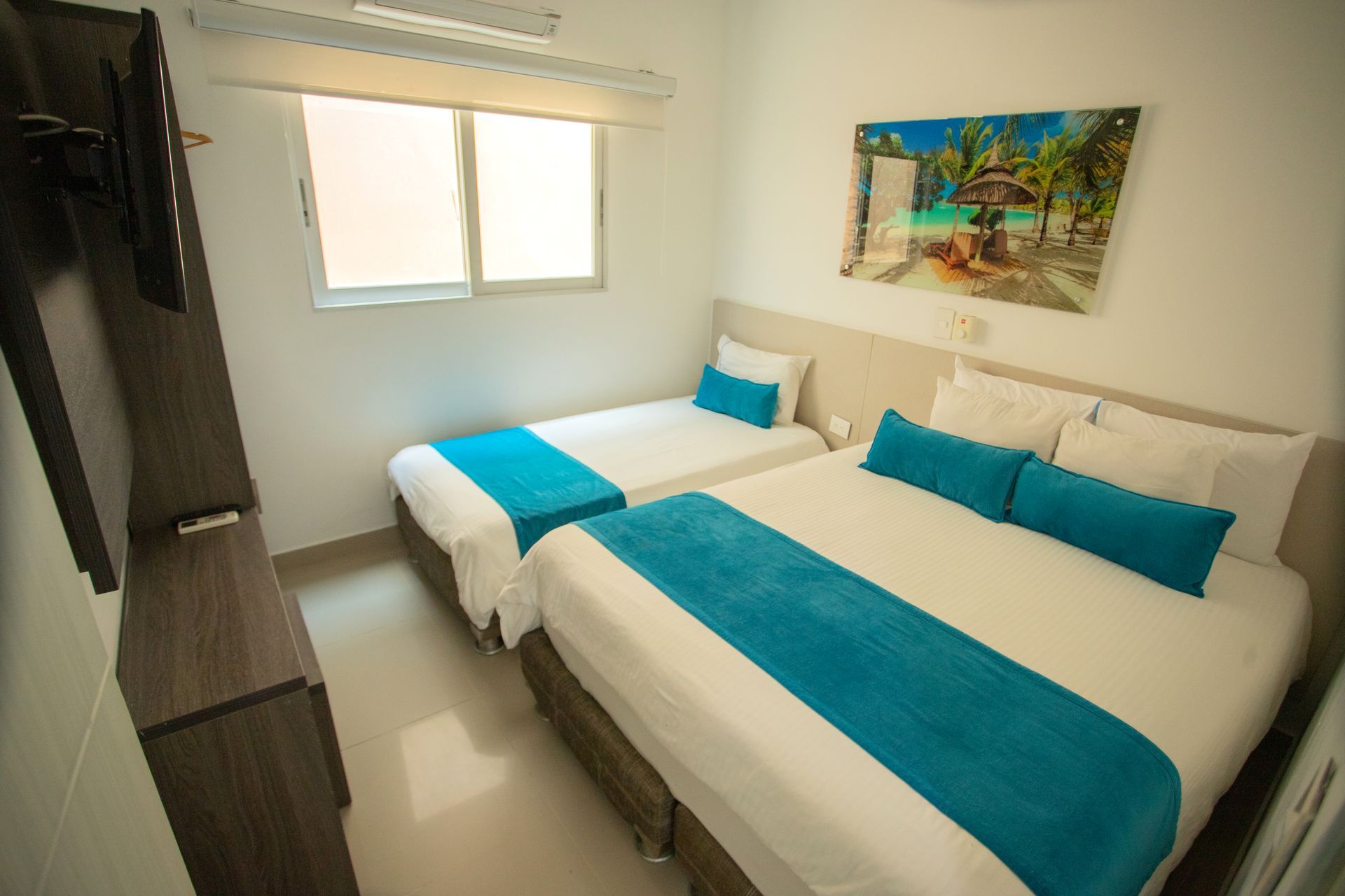 Comfortable hotel room with double and single beds for a relaxing family vacation in Coveñas at Hotel Poblado Coveñas