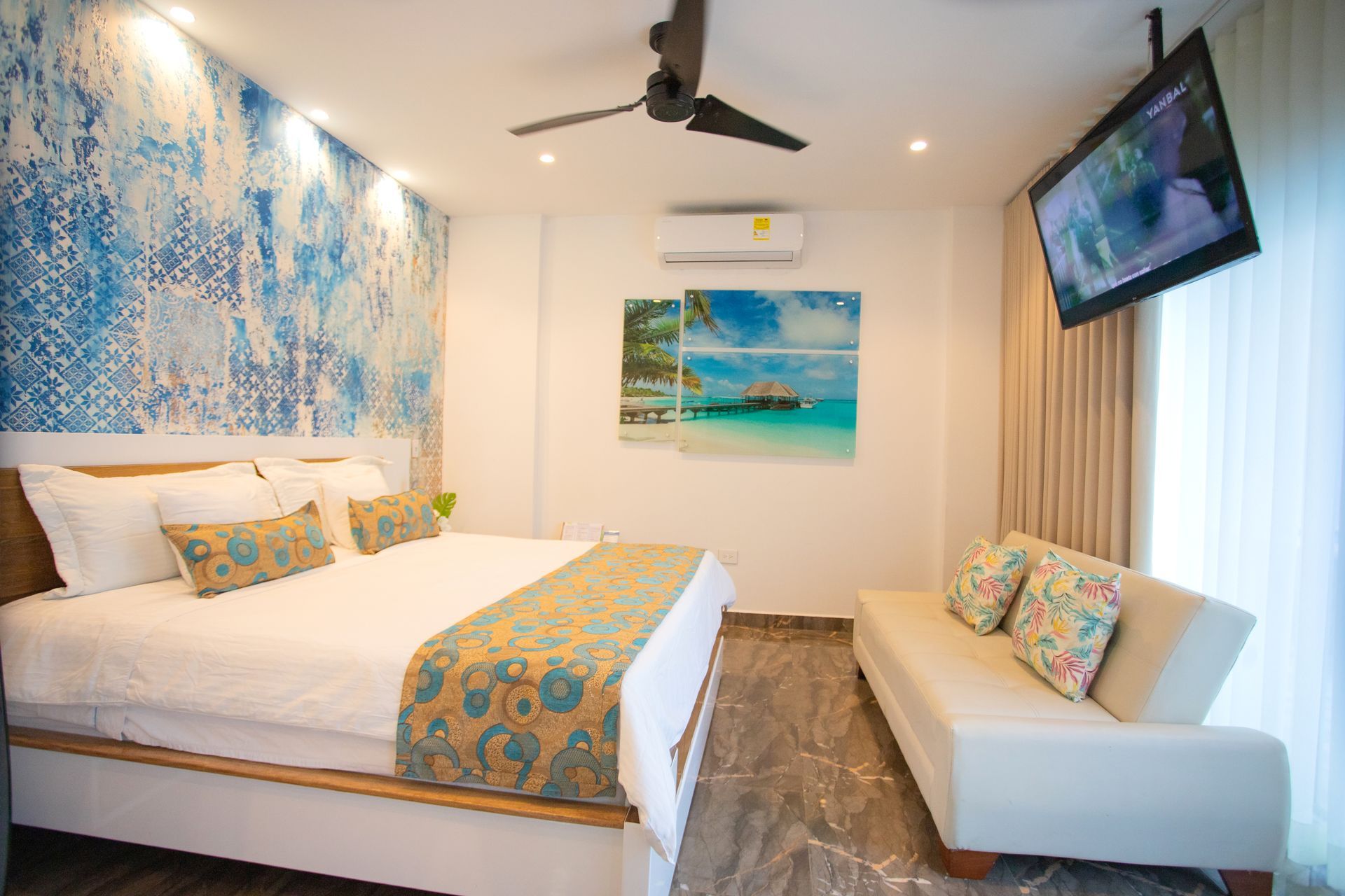Modern hotel room with double bed and sofa for your family vacation at a top beach hotel in Coveñas Colombia