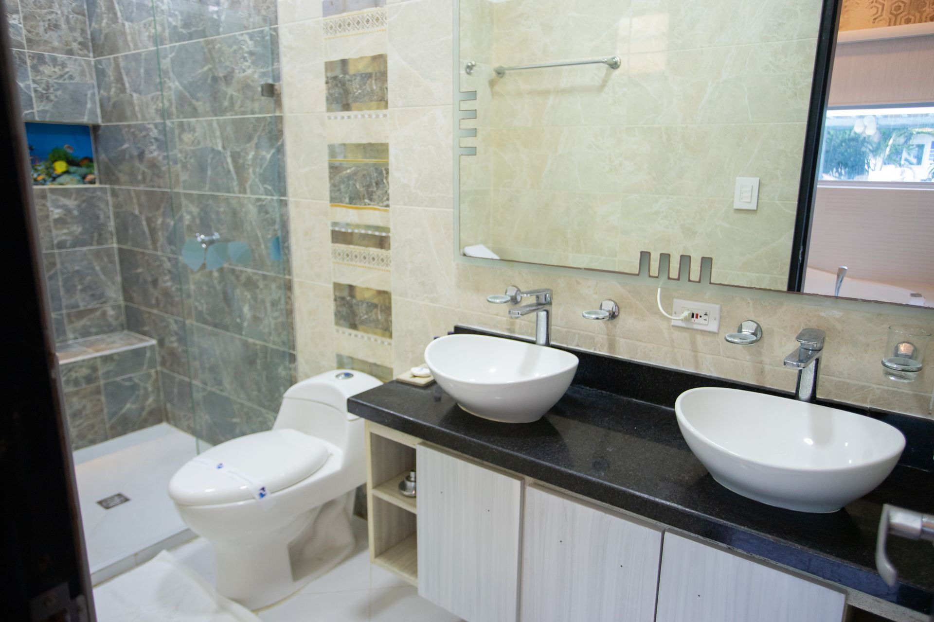 Luxury hotel bathroom with double vanity sinks and glass shower for your stay at Hotel Poblado Coveñas