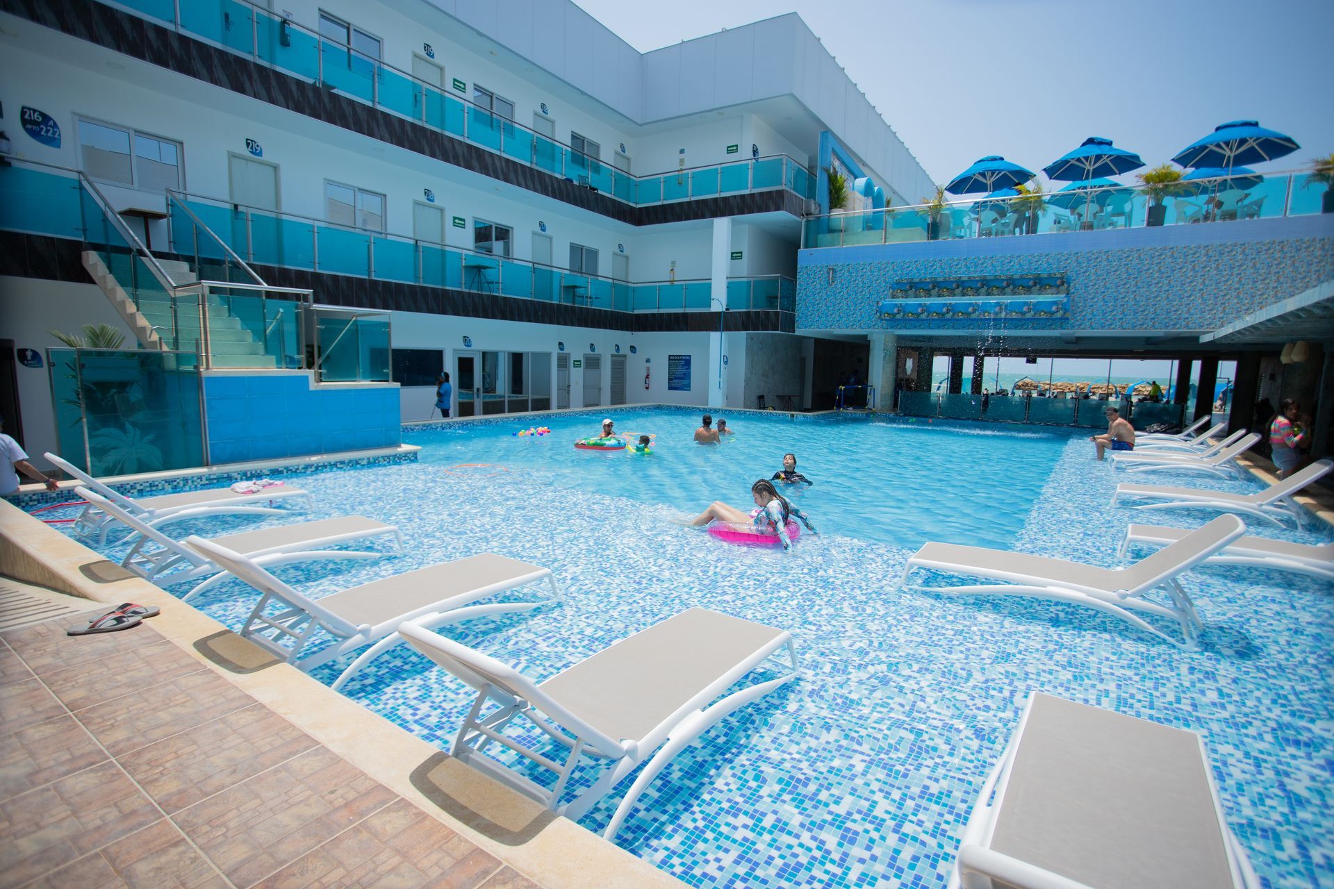 Hotel swimming pool with lounge chairs and guests relaxing during a beach vacation at Hotel Poblado Coveñas