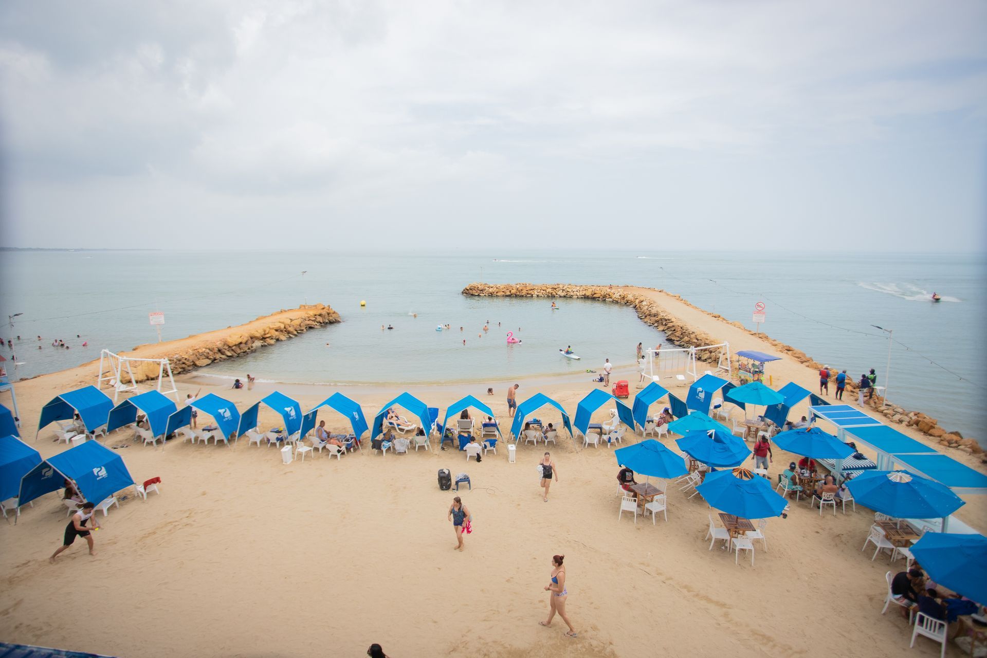 Hotel Poblado, one of the hotels in Coveñas near the beach, featuring blue tents and guests enjoying the day