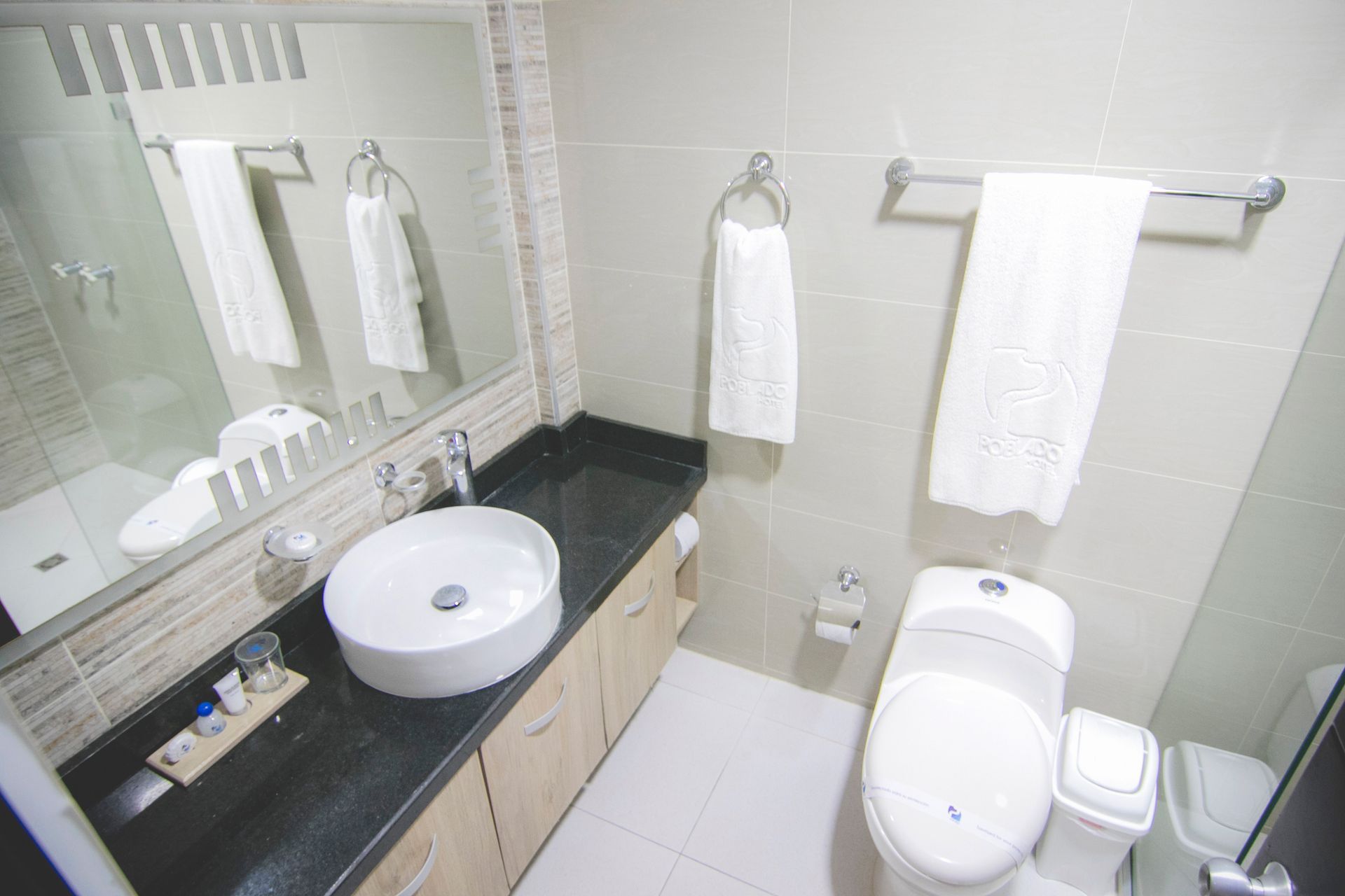 Modern hotel bathroom with vessel sink and white towels for your stay at a family friendly hotel in Coveñas