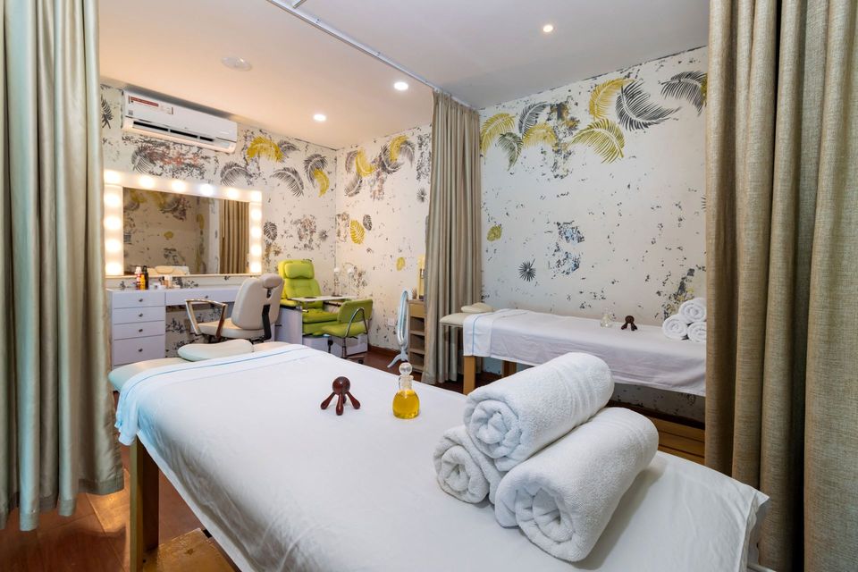 Sala de masajes con camilla, toallas blancas y espejo de camerino, en el hotel con spa Poblado Coveñas