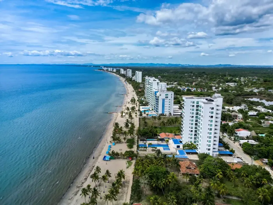 Aerial panoramic view of white buildings and Coveñas beaches under a cloudy sky in Colombia