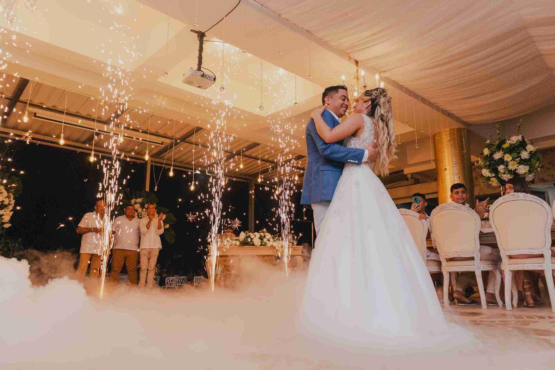 Couple dancing at their wedding reception in Coveñas surrounded by cold sparks and smoke effects at Hotel Poblado Coveñas.
