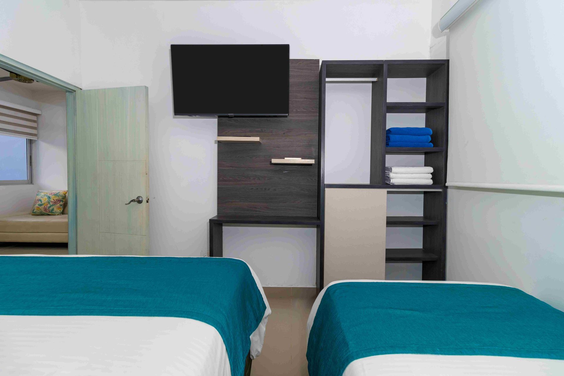 habitaciones en coveñas del Hotel Poblado con televisor, armario y camas para familias