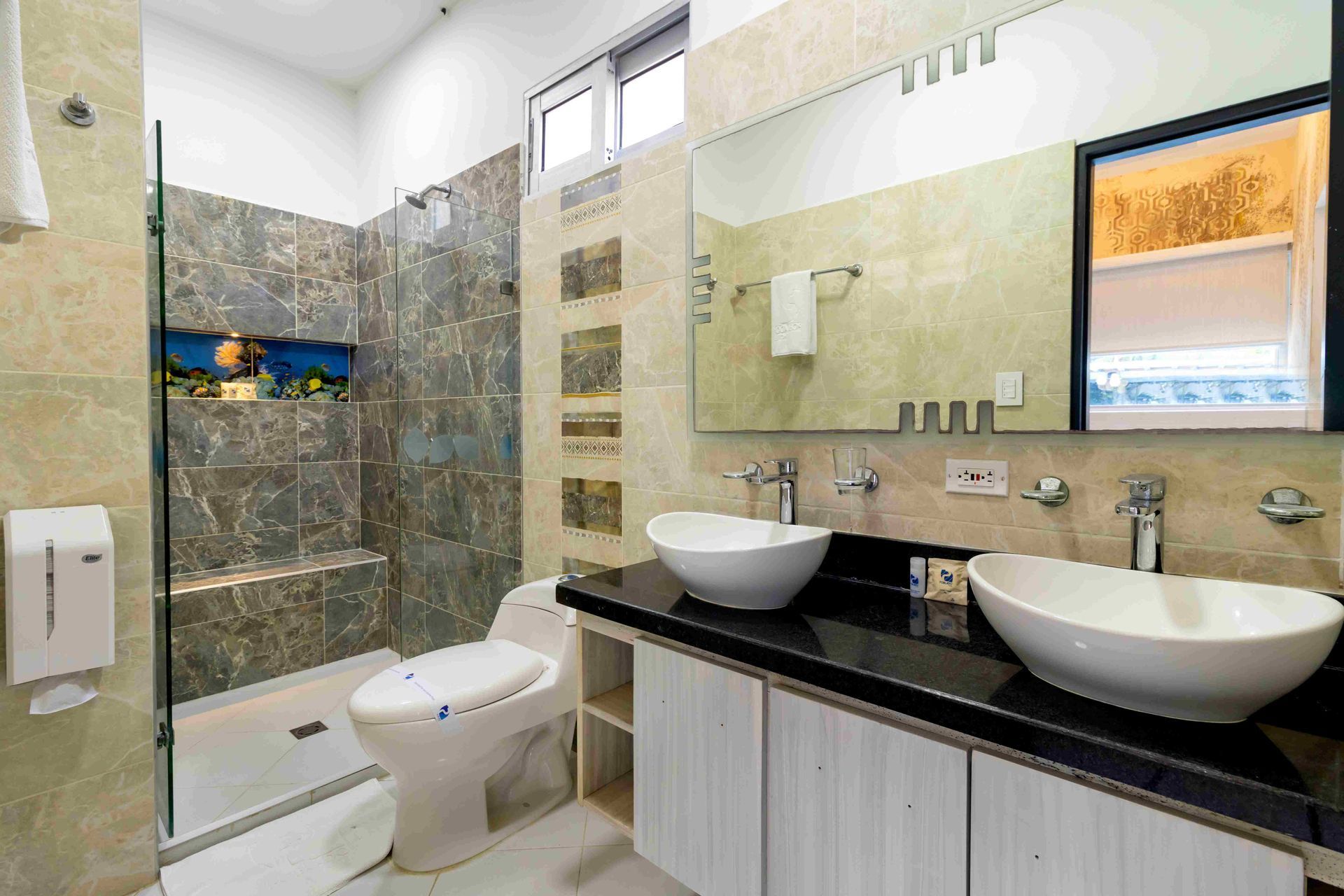 Baño amplio con doble lavabo, ducha, sanitario y espejo amplio en Hotel Poblado Coveñas