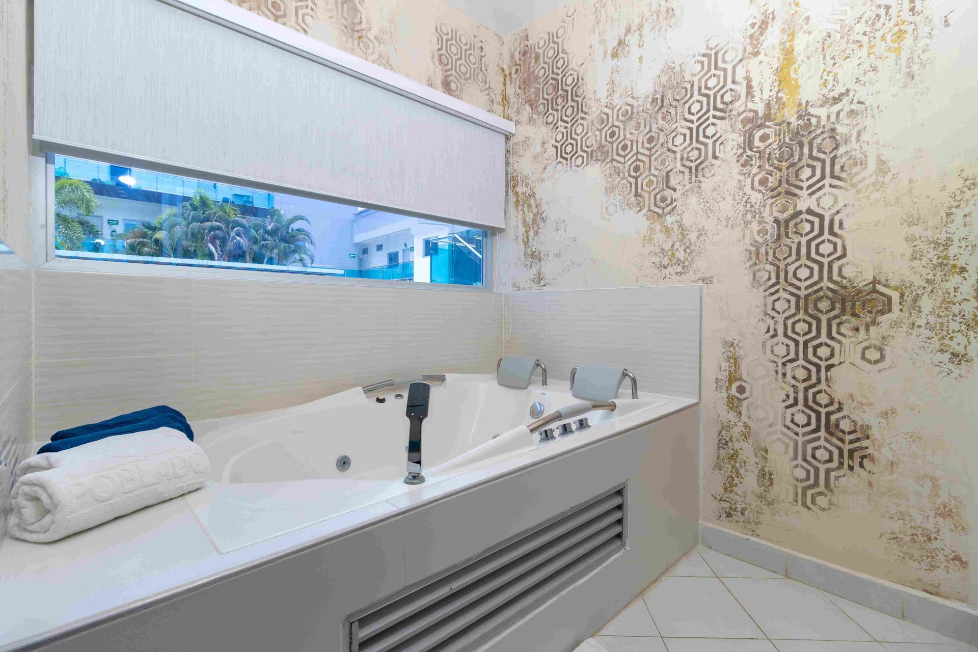 baño privado con jacuzzi, bañera de hidromasaje y acabados en tonos café en habitaciones en coveñas de Hotel Poblado