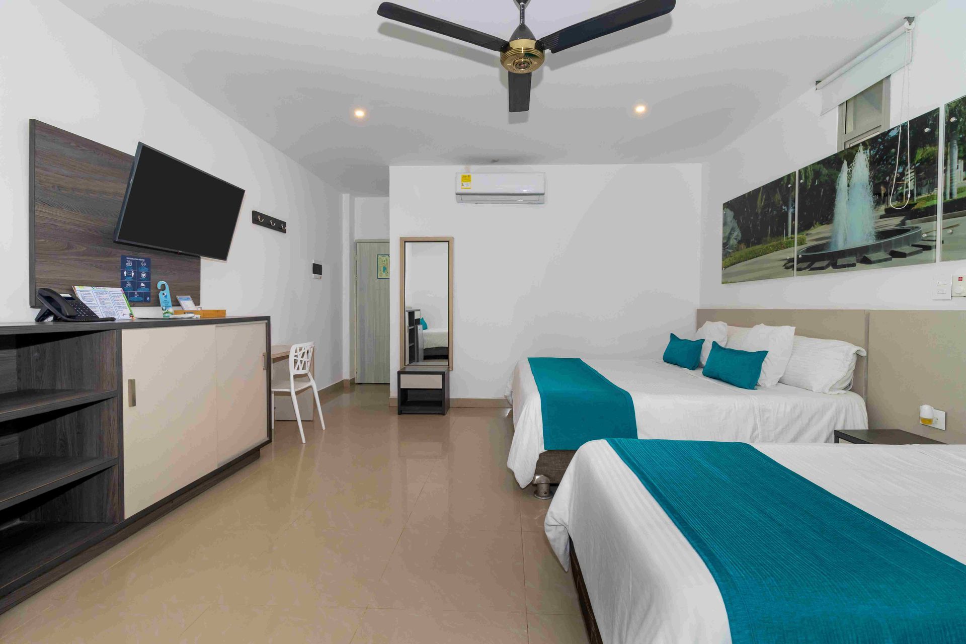 habitaciones en coveñas con dos camas dobles, televisor, aire acondicionado y escritorio en Hotel Poblado
