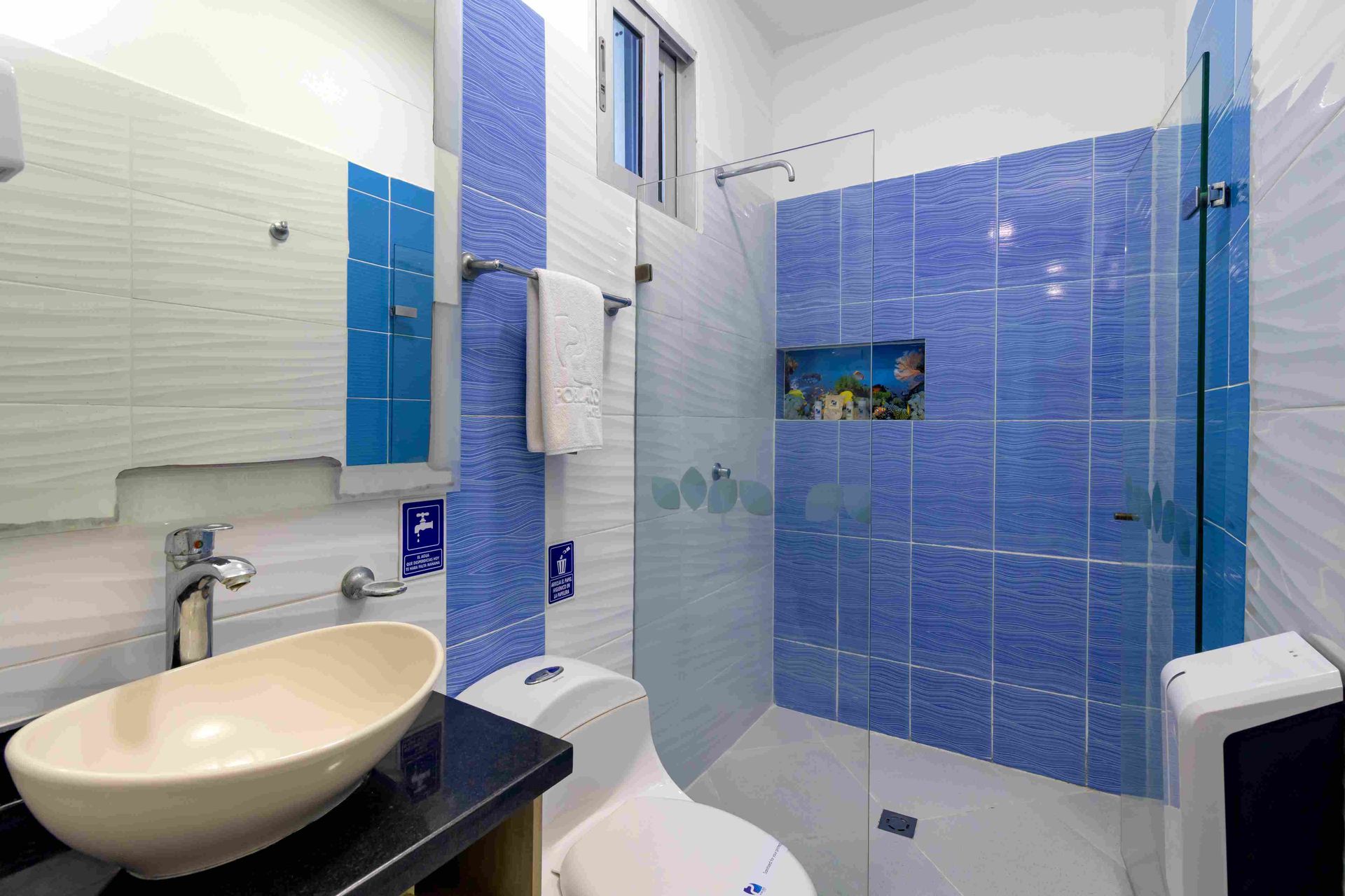 Baño moderno con detalles en azul en Hotel Poblado