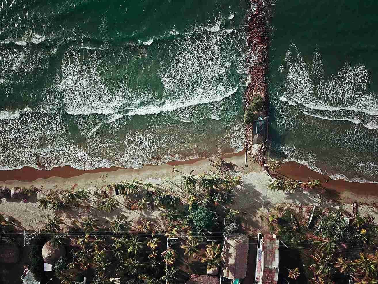 Vista aérea de la playa en Islas de San Bernardo, con muelle, palmeras y mar, plan para hacer desde Coveñas