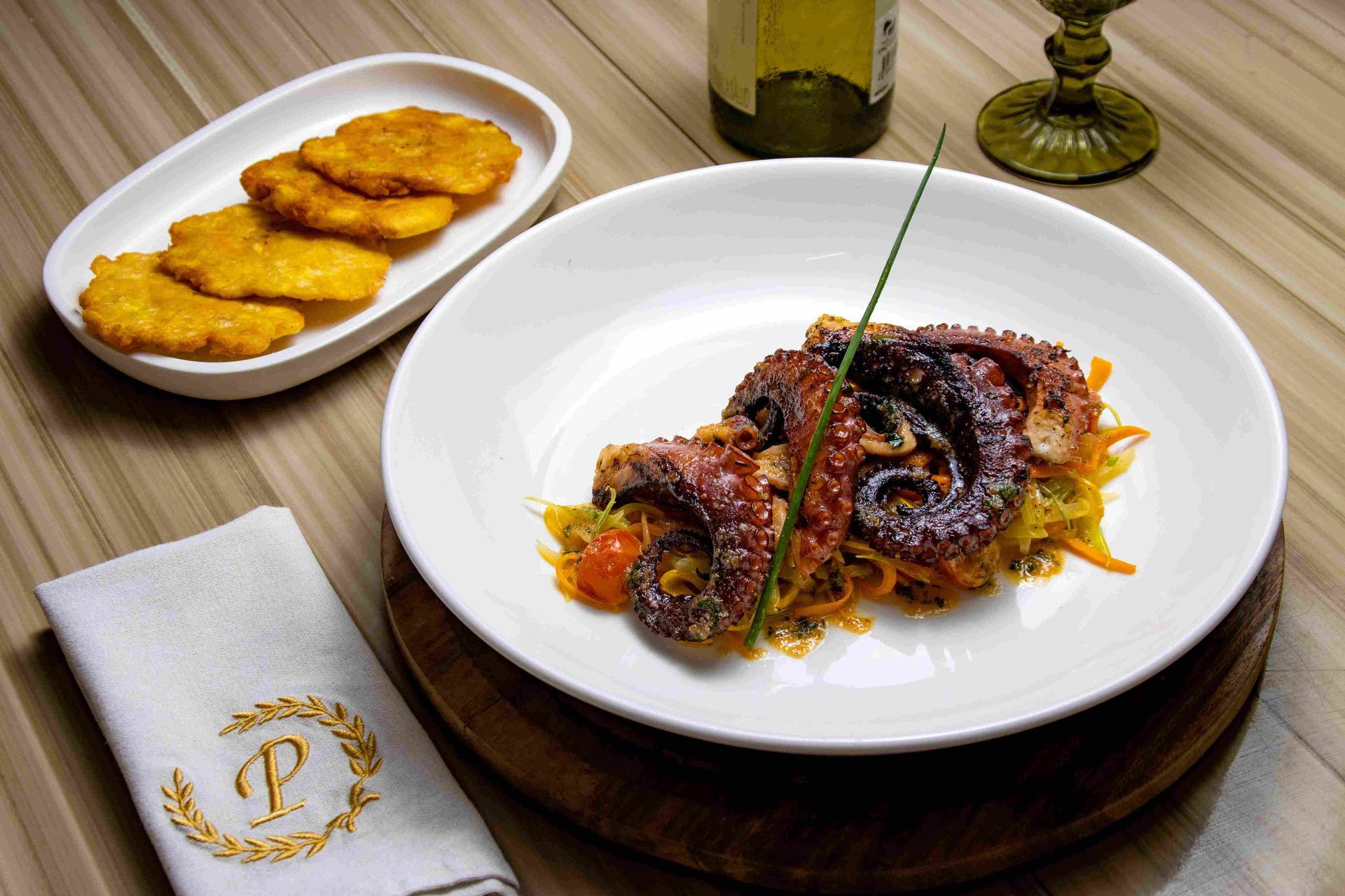 Octopus plate with patacones on a wooden table as part of the gastronomic offer for your dining choices in Coveñas