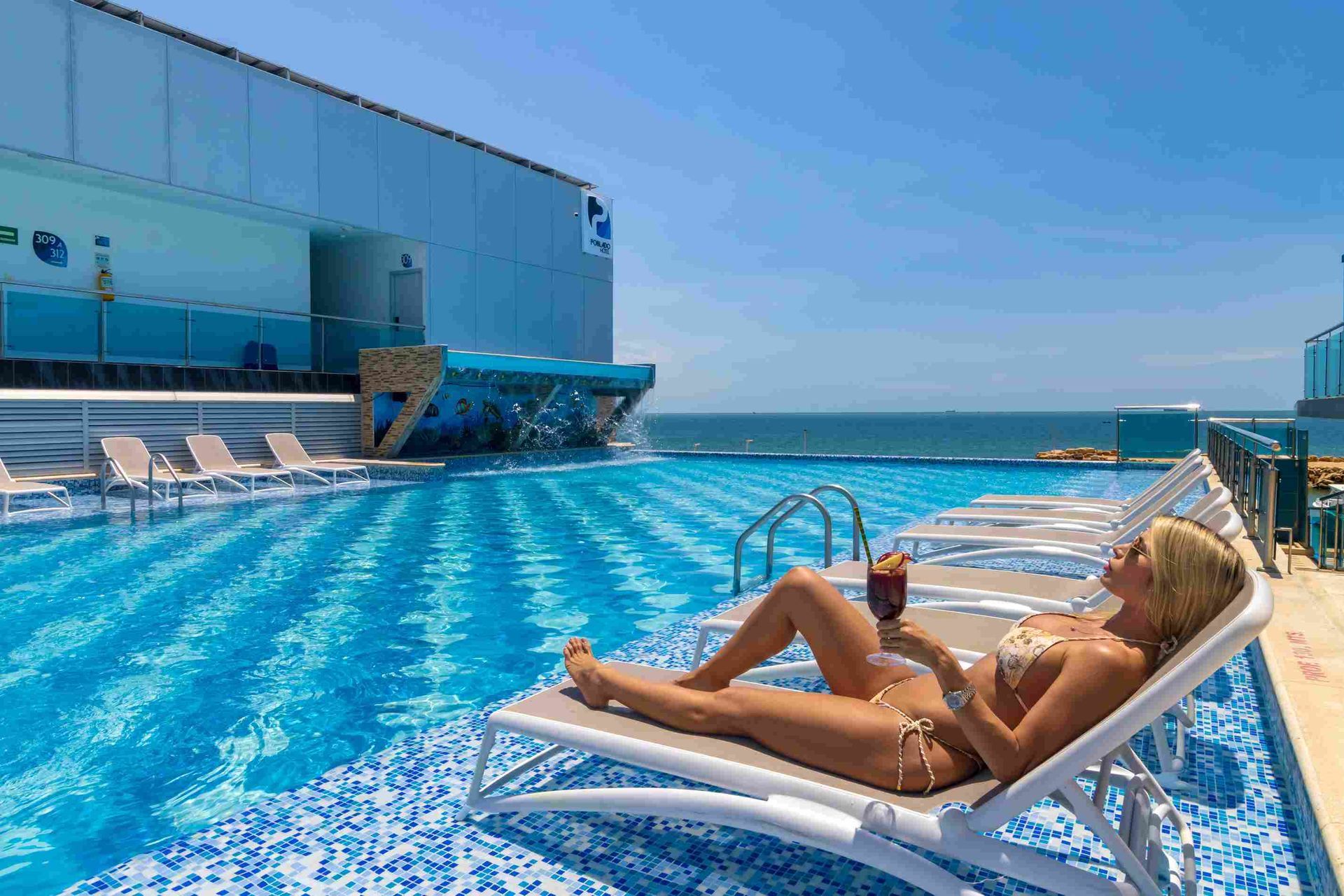 Huésped descansando en piscina con vista al mar en el Hotel Poblado Coveñas