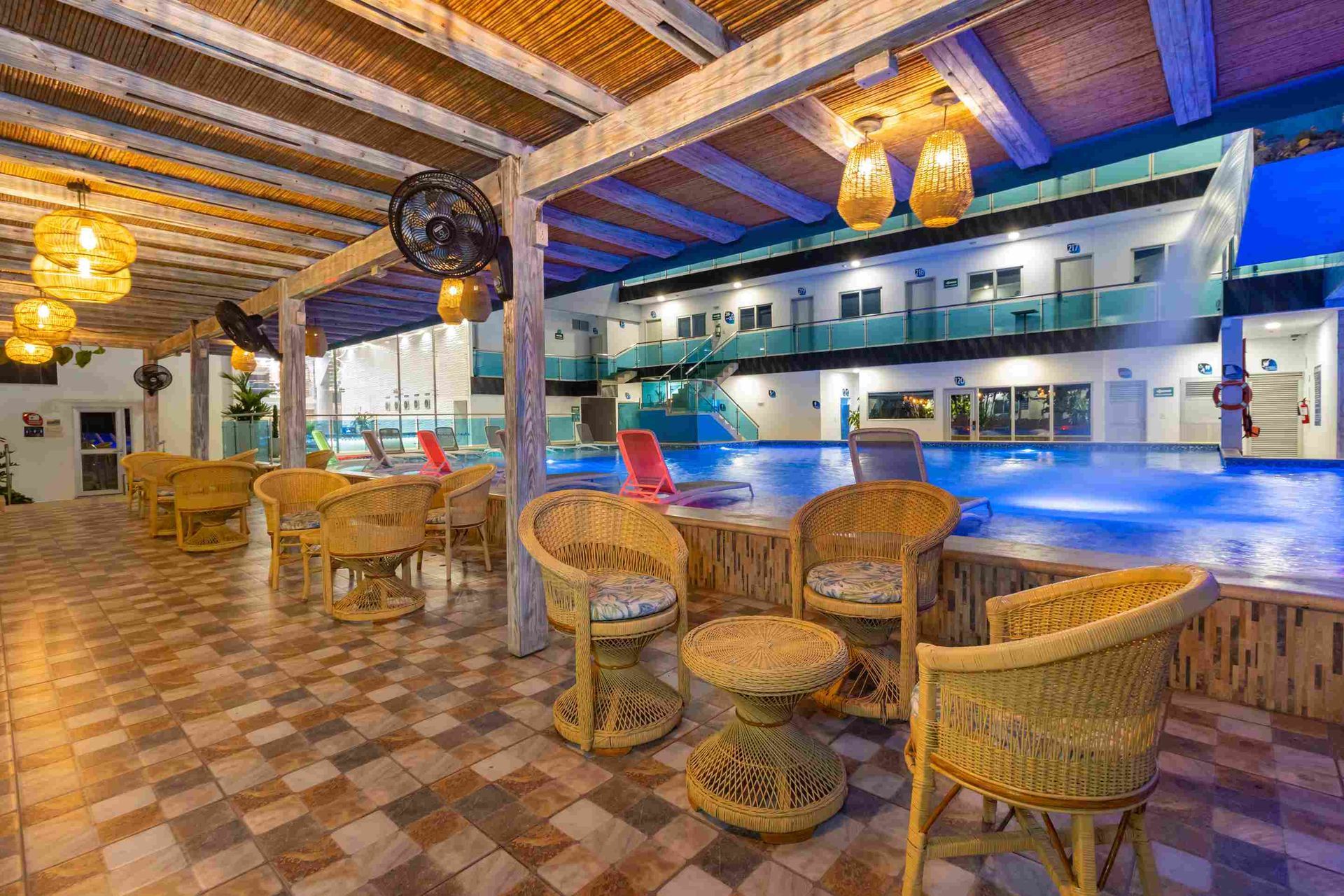 restaurante en coveñas con sillas de mimbre junto a la piscina iluminada de hotel en Coveñas