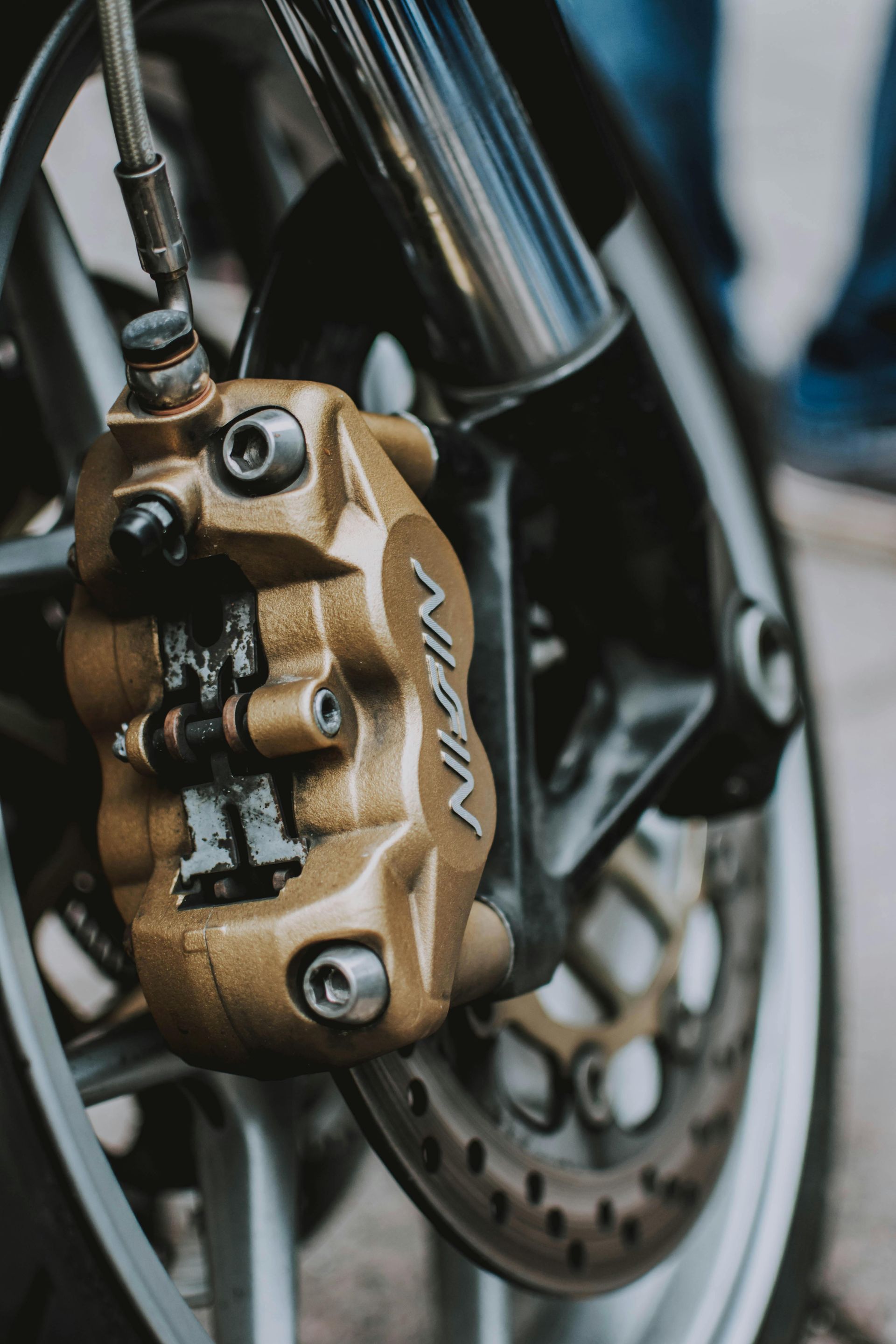 A close up of a nigin brake caliper on a motorcycle - abraham sanieoff