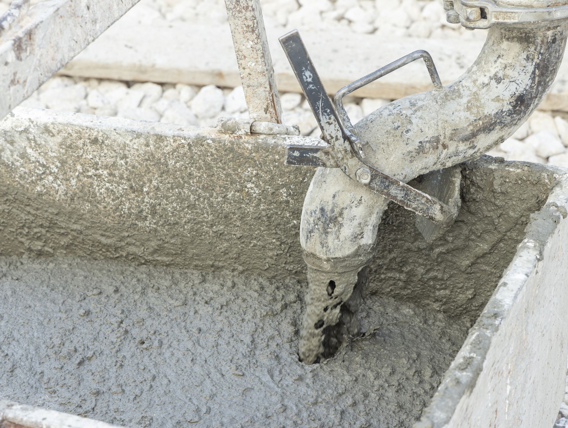 Pouring fresh ready mixed concrete from mixer into a wheelbarrow during for construction.