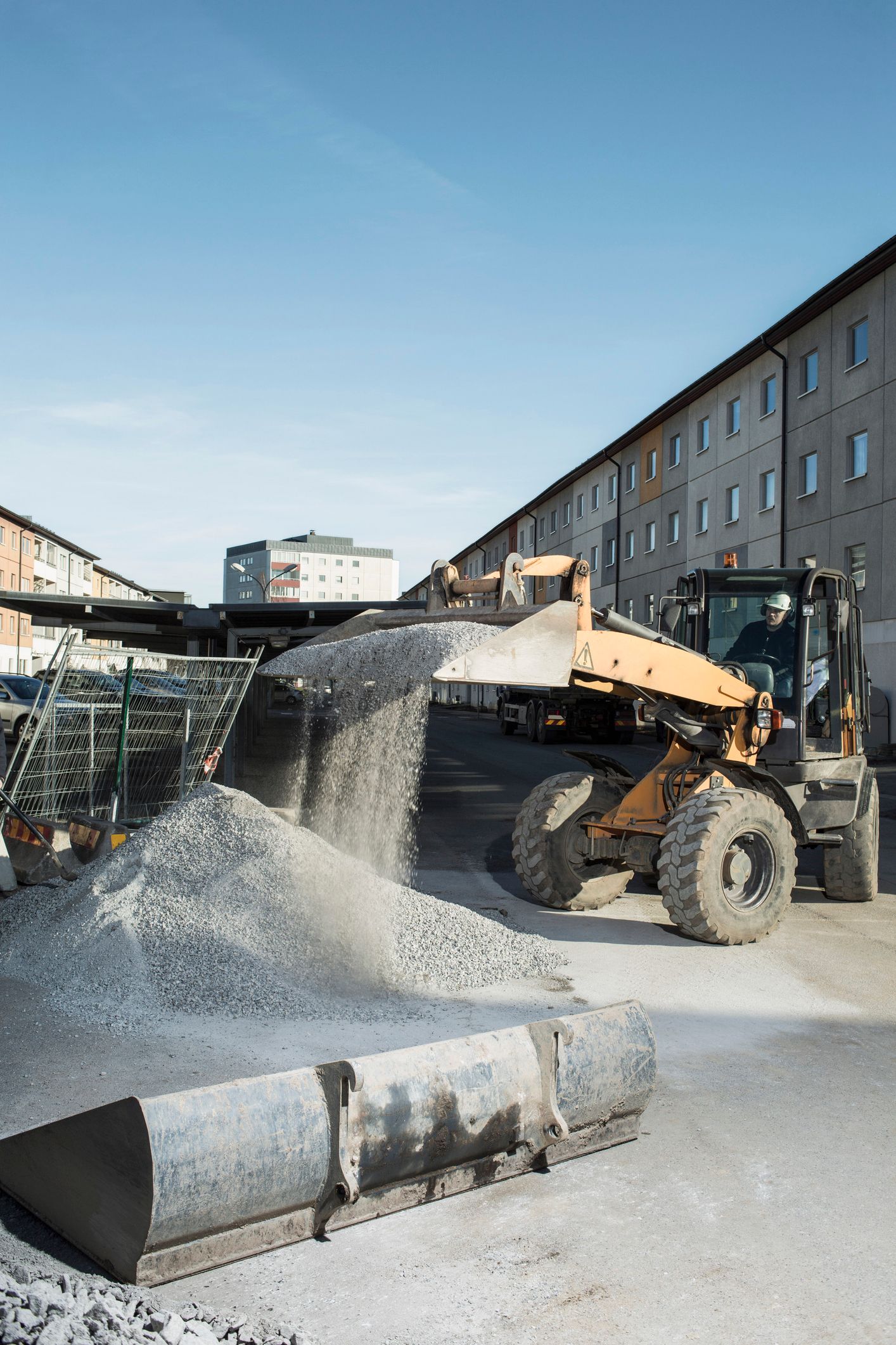 A construction worker loads sand into a truck for a concrete ready mix supplier delivery. A construction worker loads sand into a truck for a concrete ready mix supplier delivery.