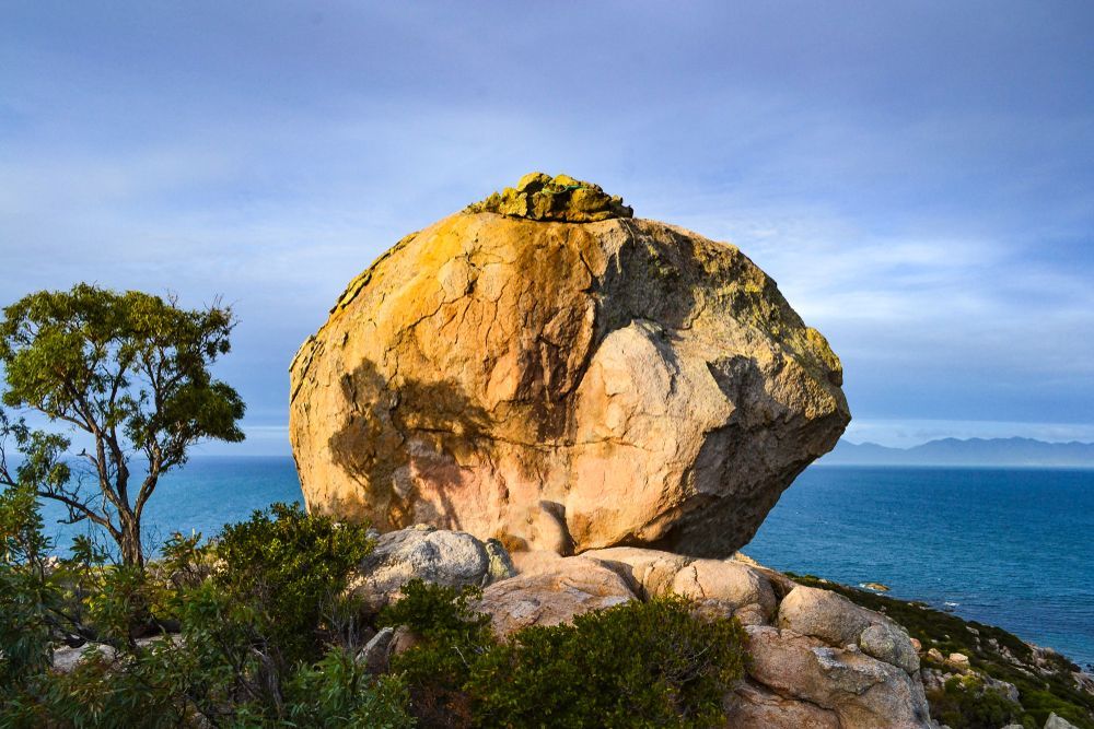 A Large Rock Sitting On Top Of A Cliff Overlooking The Ocean — PGI North QLD In Bowen, QLD