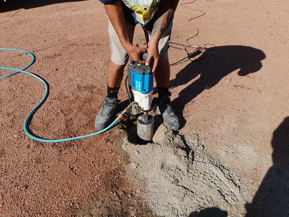 A Man Is Using A Machine To Dig A Hole In The Ground — PGI North QLD In Ingham, QLD