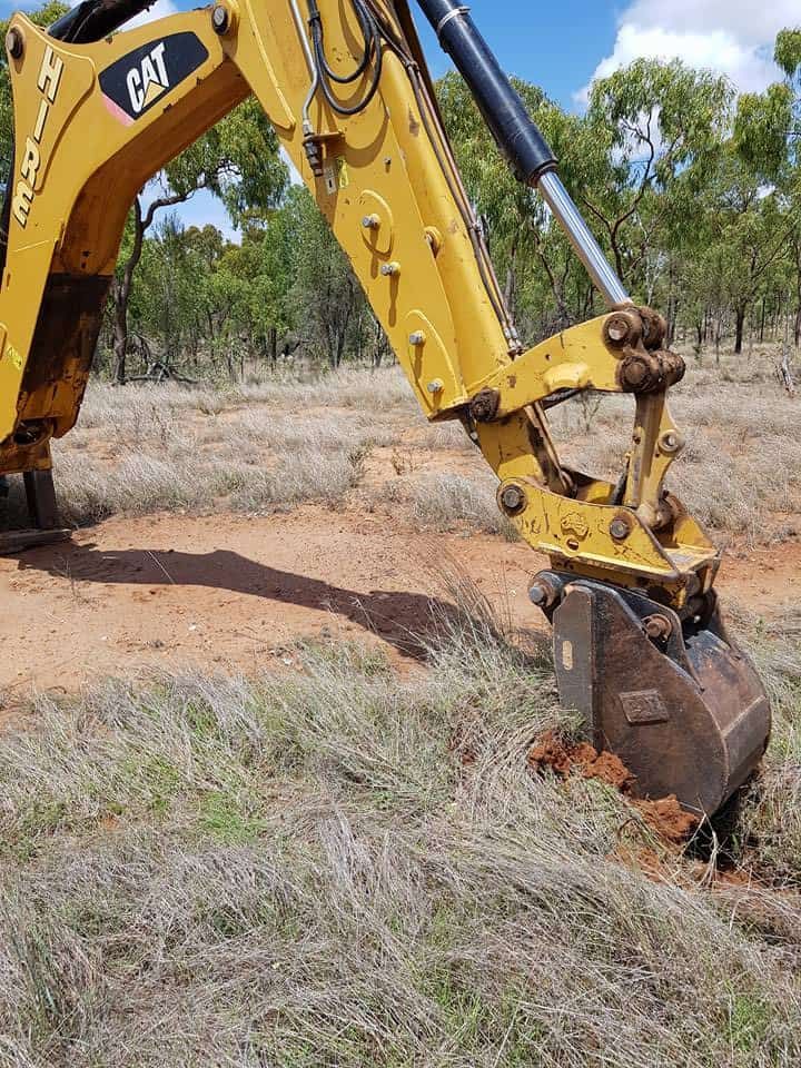 A Yellow Excavator Is Digging A Hole In The Ground — PGI North QLD In Ingham, QLD