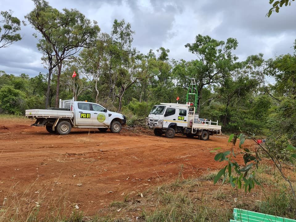 Two White Trucks Are Parked In A Dirt Field — PGI North QLD In Ingham, QLD