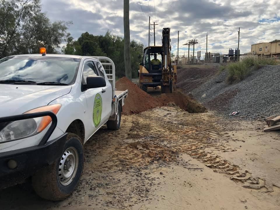 A White Truck Is Parked Next To An Excavator — PGI North QLD In Cardwell, QLD
