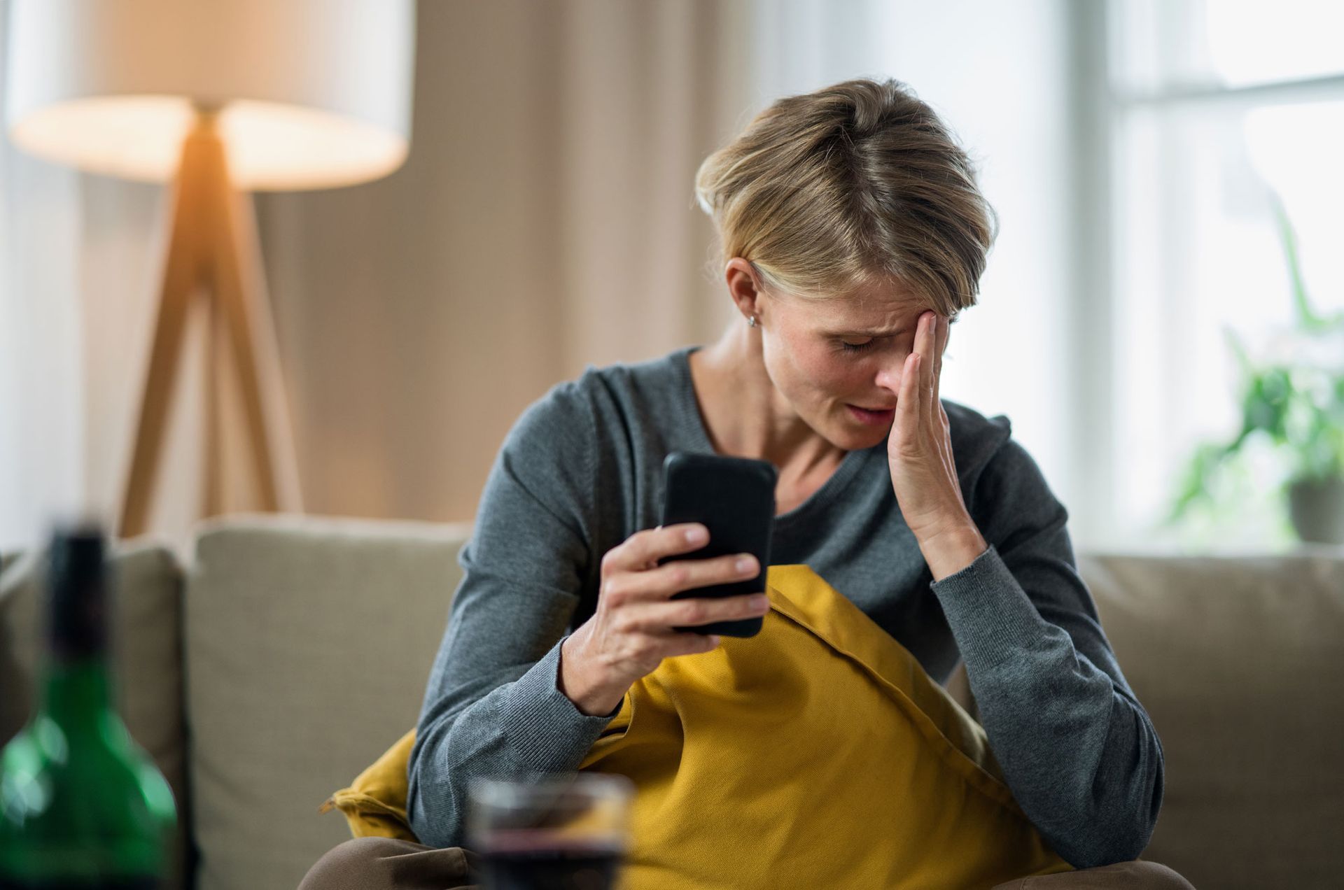 Distressed woman looking at husband's phone