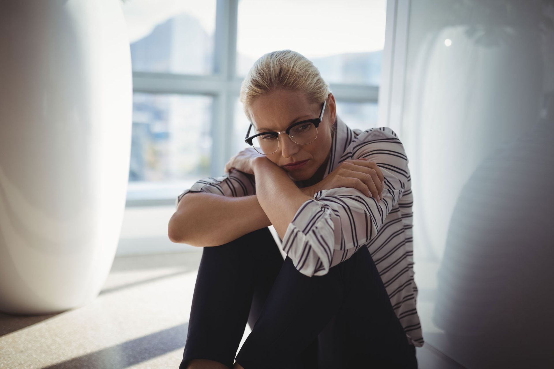 Upset woman hunched over in home