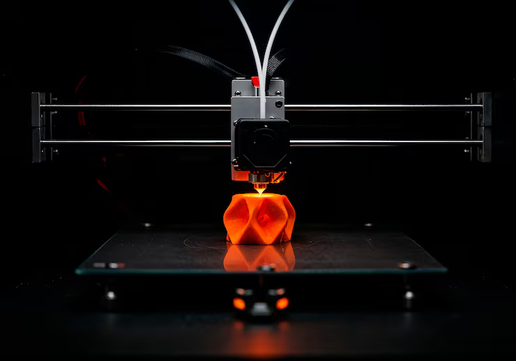 A 3D printer building an orange part