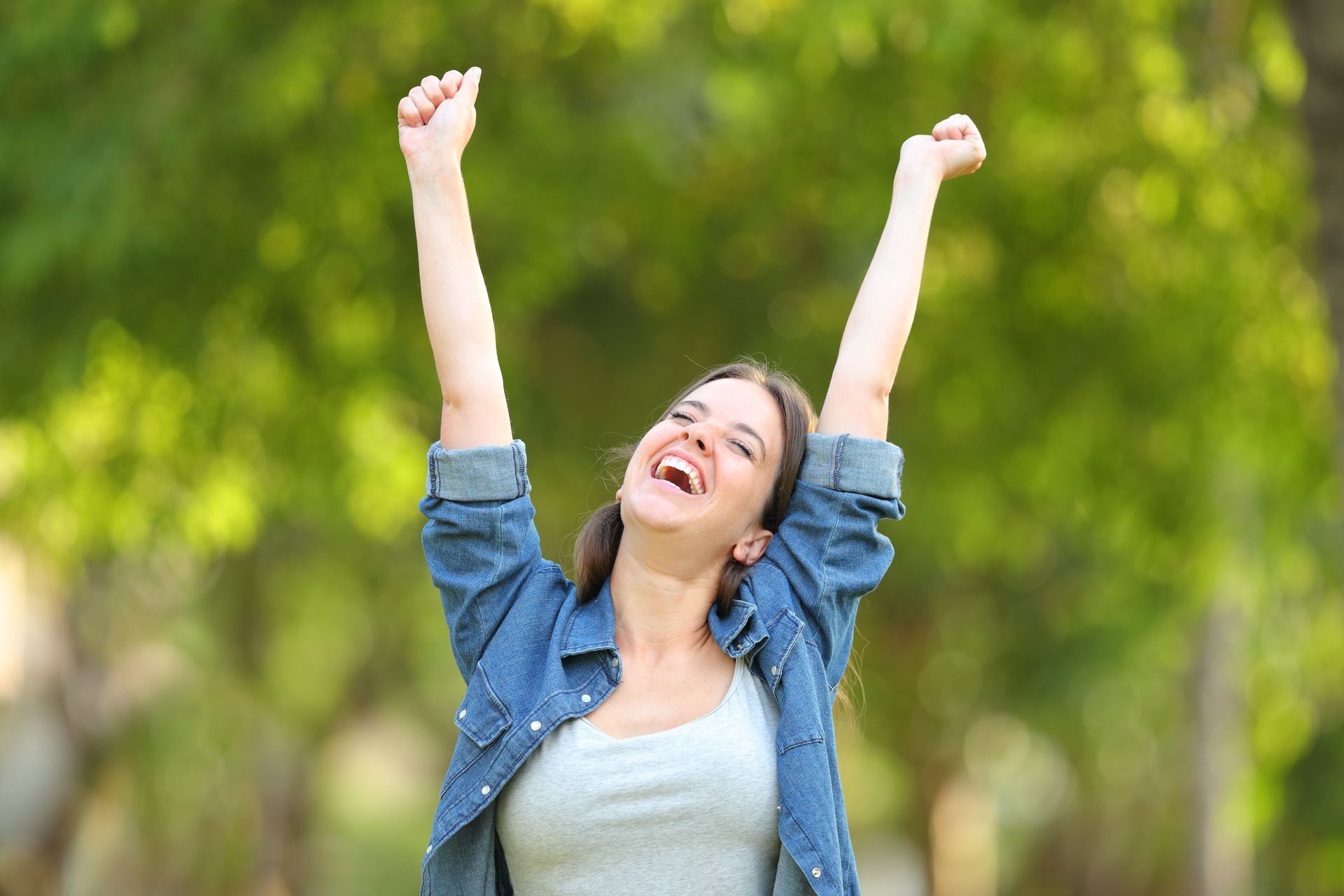 Happy woman with arms in the air.