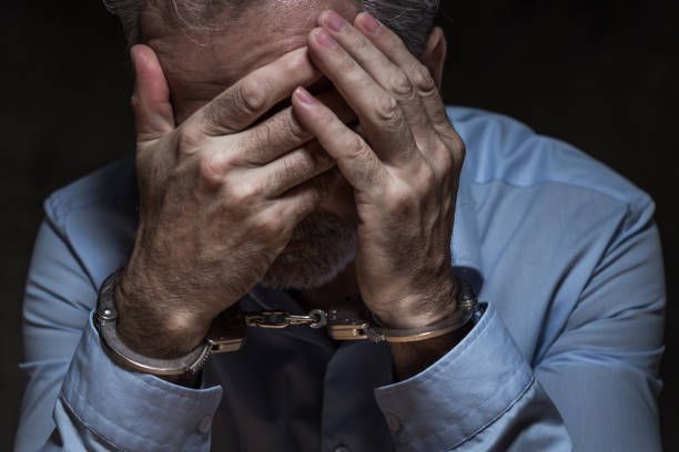 Frustrated businessman behind bars confused about how bail bond services work.