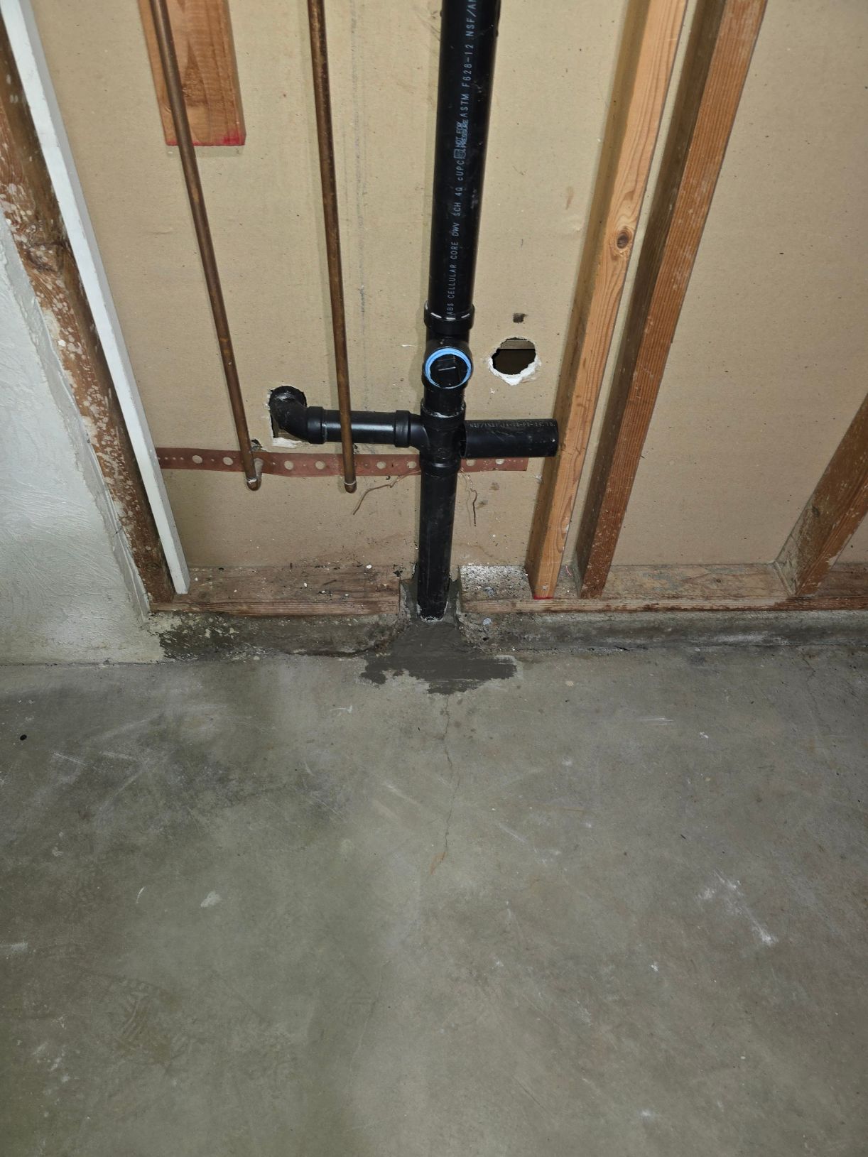 Technician adjusting a wall-mounted water heater with tools in a tiled room