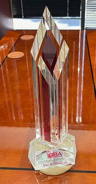 A glass trophy is sitting on top of a wooden table.
