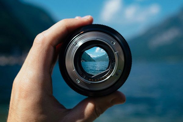 TIME TO SELL? SALES OF PRIVATELY HELD BUSINESSES TRENDING UPWARD Hand holding camera lens