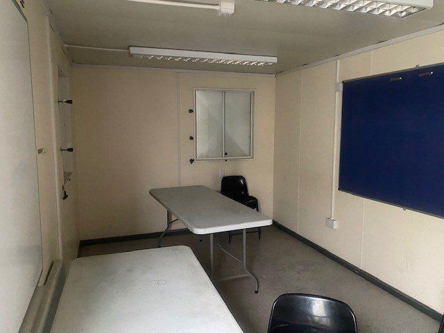 A room inside an anti-vandal cabin featuring a table and chairs